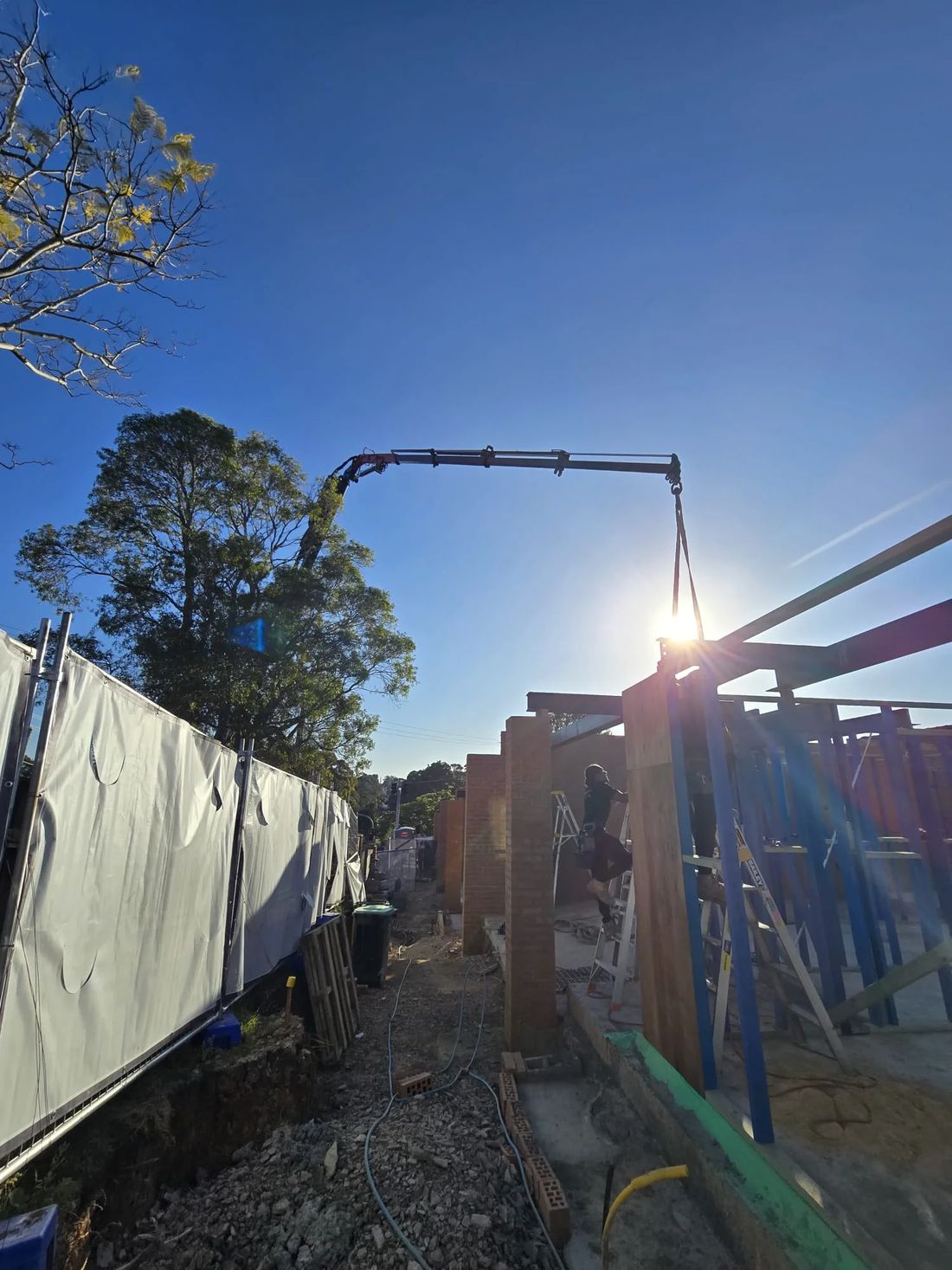 Crane working between wall frames and scaffold