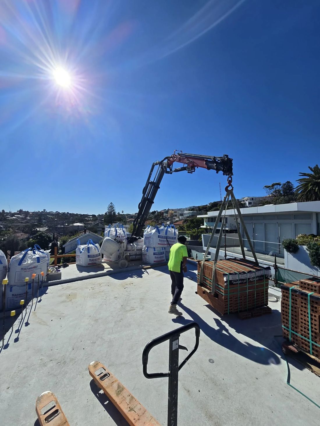 Level8 crane lifting pallets onto a rooftop slab in Sydney
