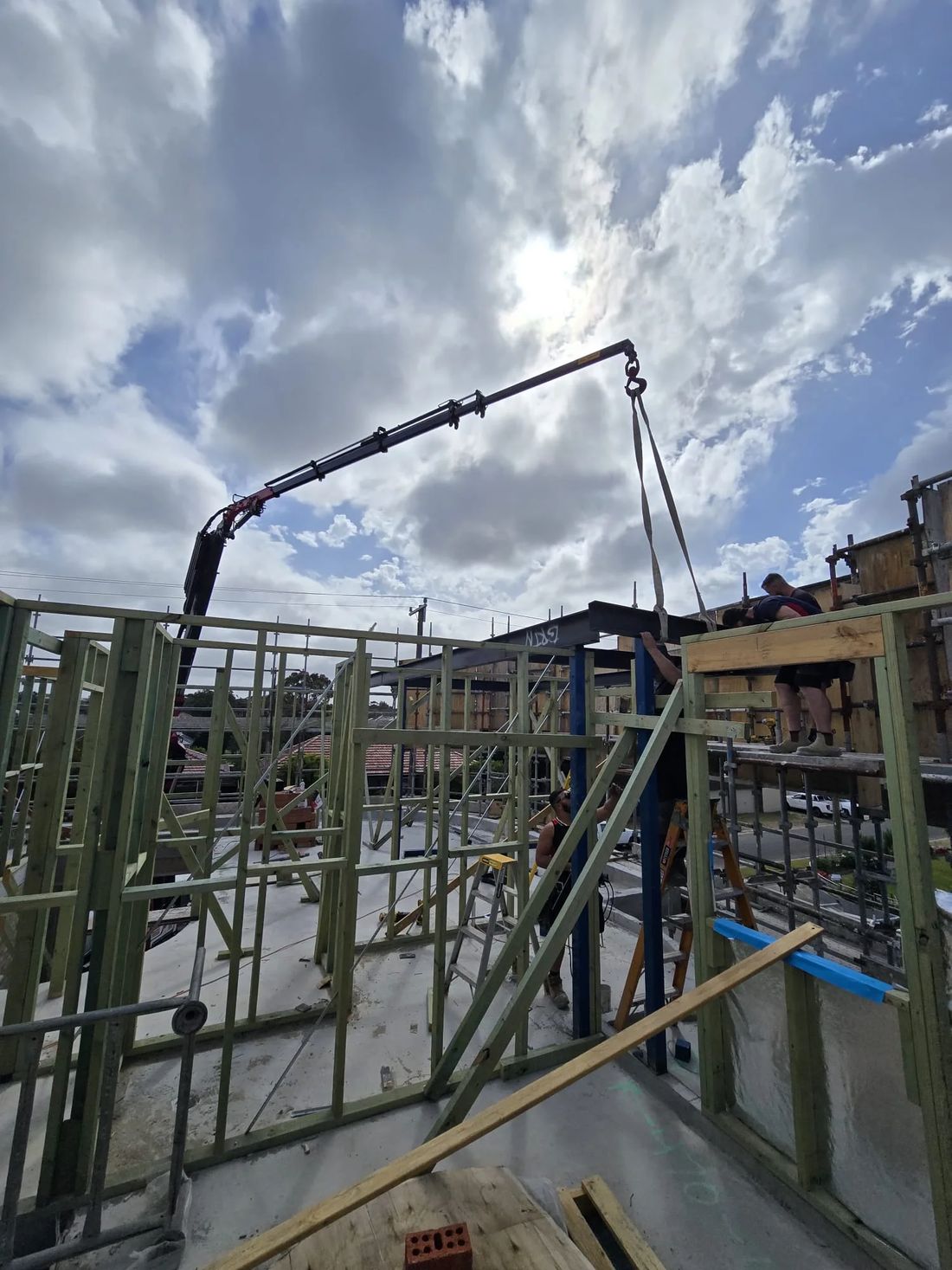 Crane lifting over a timber-framed build